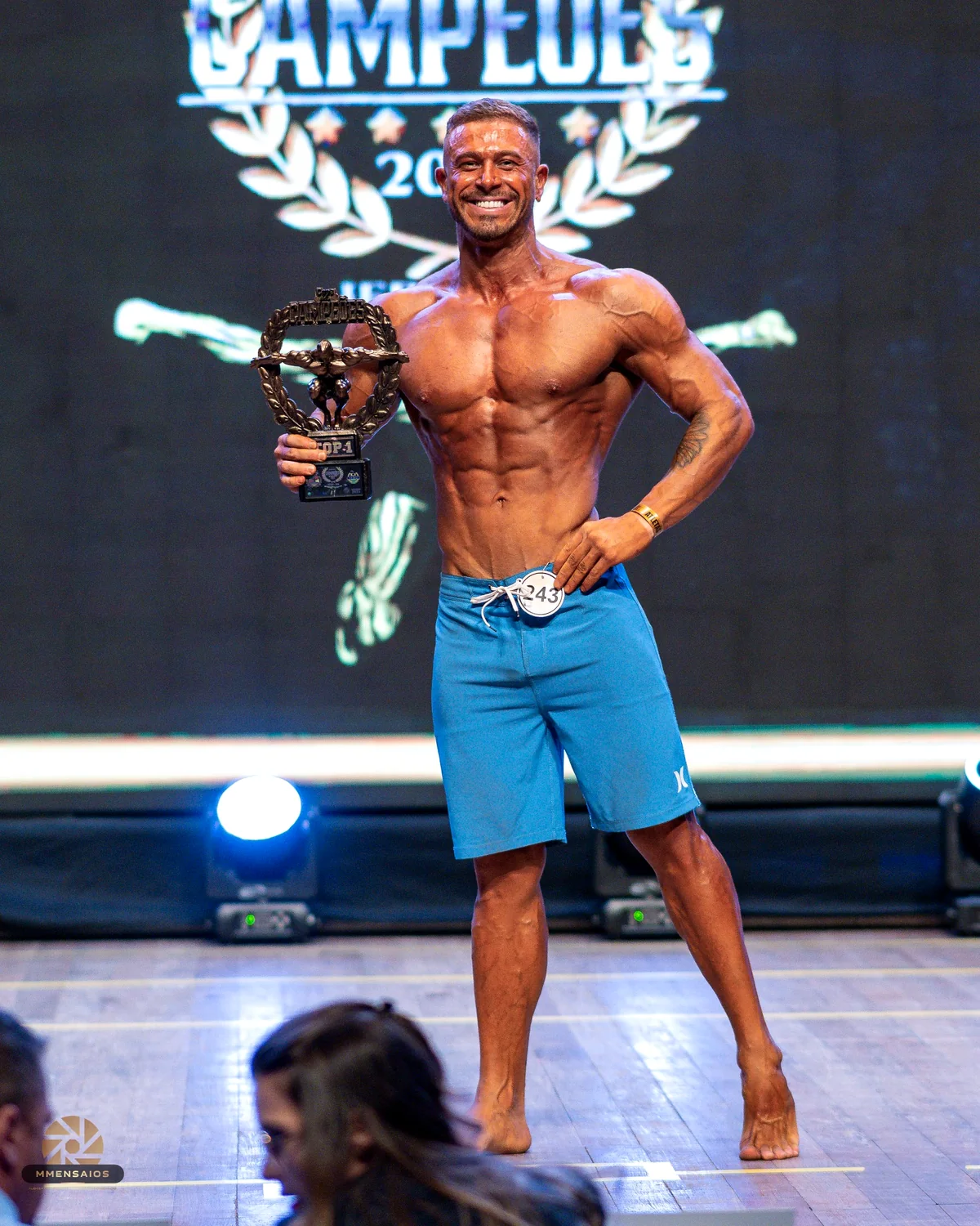 Matheus Correa no palco com troféu de fisiculturismo