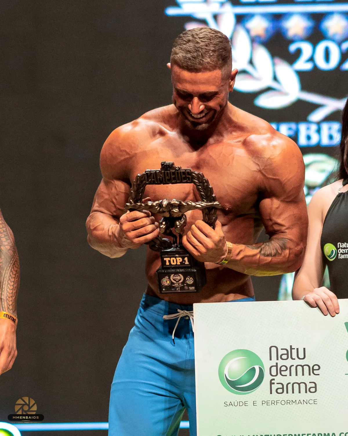 Matheus Correa recebendo troféu em competição de fisiculturismo