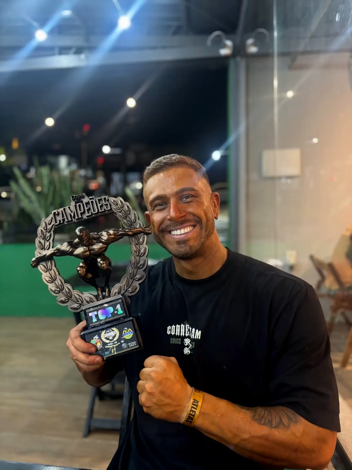 Matheus Correa sorrindo e segurando troféu de competição